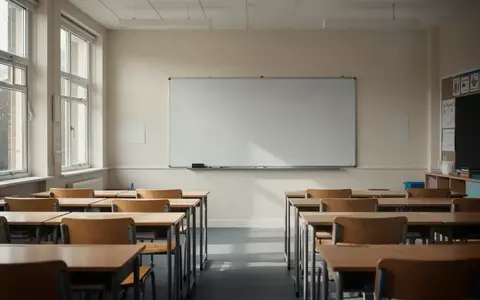 Ein heller, moderner Klassenraum in einer Schule mit leeren Tischen und Stühlen vor einer sauberen weißen Tafel. - Foto: über boerse-global.de