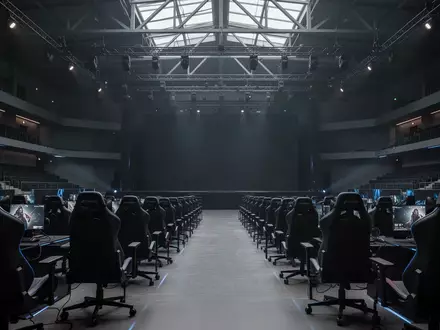 Ein leerer, modern gestalteter E-Sport-Austragungsort mit professionellen Gaming-Stühlen in einer abgedunkelten Arena. - Foto: über boerse-global.de