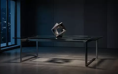 Ein minimalistischer, dunkler BĂŒroraum mit einer abstrakten Metallskulptur auf einem leeren Schreibtisch. - Foto: ĂŒber boerse-global.de