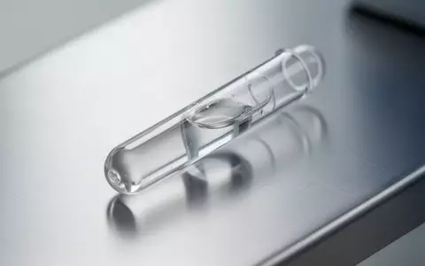 Ein Labor-Reagenzglas mit einer klaren Flüssigkeit auf einer metallischen Oberfläche, das die medizinische Diagnostik symbolisiert. - Foto: über boerse-global.de
