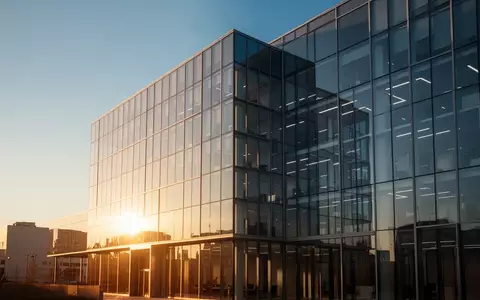 Ein modernes Bürogebäude bei Sonnenuntergang als Symbol für die strategische Fusion zweier Finanzunternehmen. - Foto: über boerse-global.de
