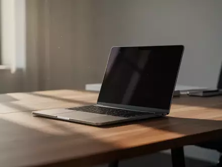 Ein minimalistischer Büroarbeitsplatz mit einem Laptop auf einem Holztisch bei natürlichem Tageslicht. - Foto: über boerse-global.de