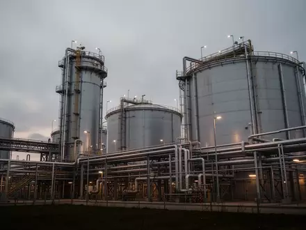 Moderne Industrieanlage mit Treibstofftanks und Rohrleitungssystemen bei Dämmerung. - Foto: über boerse-global.de