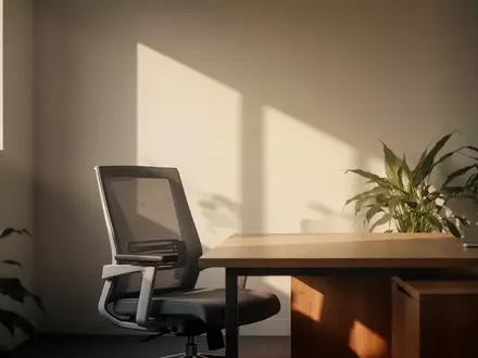 Ein minimalistischer, sonnendurchfluteter Arbeitsplatz mit einem leeren Schreibtisch und einer Pflanze in einem ruhigen Büro. - Foto: über boerse-global.de
