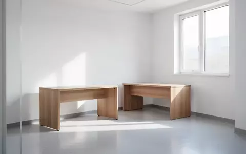 Ein minimalistischer, lichtdurchfluteter Behandlungsraum in einer Arztpraxis mit sauberem Schreibtisch und ruhiger Atmosphäre. - Foto: über boerse-global.de