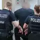 Ein Mann aus dem Umfeld der «Hells Angels» wird in Duisburg abgeführt. - Bild: Christoph Reichwein/dpa