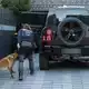 Eine Polizeibeamtin mit ihrem Diensthund durchsucht einen Pkw eines Mannes aus dem Umfeld der Hells Angels. - Bild: Christoph Reichwein/dpa