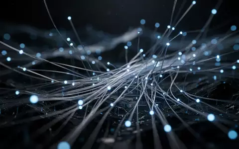 Abstrakte digitale Netzwerkstruktur mit leuchtenden Lichtknoten und Glasfaserkabeln in dunkler Umgebung. - Foto: über boerse-global.de