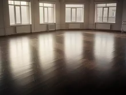 Ein leerer, sonnendurchfluteter Tanzsaal mit poliertem Holzboden, der eine Atmosphäre von Disziplin und Ausdauer ausstrahlt. - Foto: über boerse-global.de