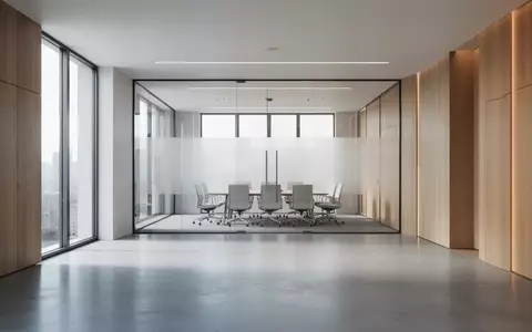 Ein minimalistischer, moderner Konferenzraum in einem Regierungsgebäude mit Glaswänden und Holzelementen bei natürlichem Licht. - Foto: über boerse-global.de