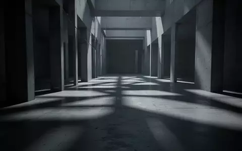 Ein minimalistischer, düsterer Innenraum mit geometrischen Schatten auf einem Betonboden, der eine Atmosphäre der Überwachung vermittelt. - Foto: über boerse-global.de