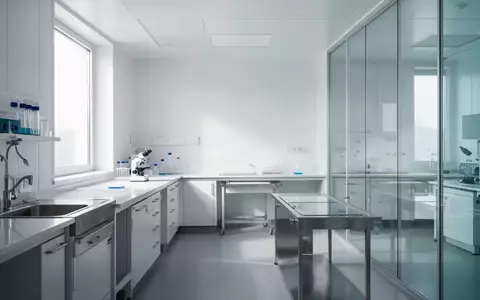 Ein minimalistisches, modernes Labor mit sterilen Oberflächen und diffusem Tageslicht, das einen Forschungsbereich symbolisiert. - Foto: über boerse-global.de