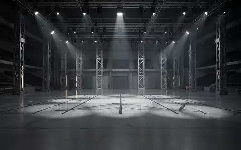 Eine leere, modern beleuchtete Arena mit poliertem Betonboden und industrieller Architektur für ein Robotik-Testevent. - Foto: über boerse-global.de