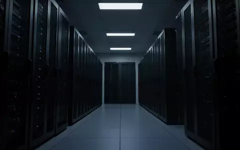 Dunkler, moderner Serverraum mit anonymen technologischen Schränken in einer kühlen, schattenreichen Umgebung. - Foto: über boerse-global.de