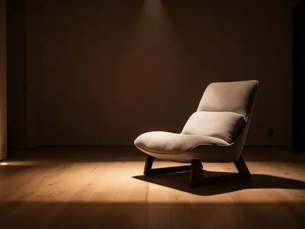 Ein minimalistischer und ruhig gestalteter Ruheraum mit einem bequemen Sessel in einer atmosphärisch gedimmten Umgebung. - Foto: über boerse-global.de