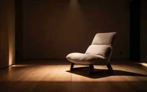 Ein minimalistischer und ruhig gestalteter Ruheraum mit einem bequemen Sessel in einer atmosphärisch gedimmten Umgebung. - Foto: über boerse-global.de