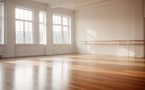 Ein heller, leerer Tanzsaal mit poliertem Holzboden und natürlichem Lichteinfall durch große Fenster. - Foto: über boerse-global.de