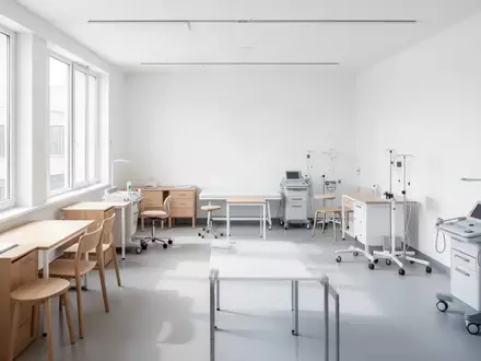 Ein heller, moderner Unterrichtsraum in einer Pflegeschule mit minimalistischen Möbeln und medizinischen Übungsgeräten. - Foto: über boerse-global.de