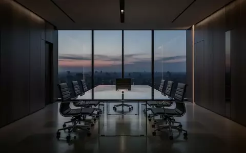 Modernes, schlichtes Bürointerieur im Dämmerlicht mit einem Konferenztisch und ergonomischen Stühlen. - Foto: über boerse-global.de