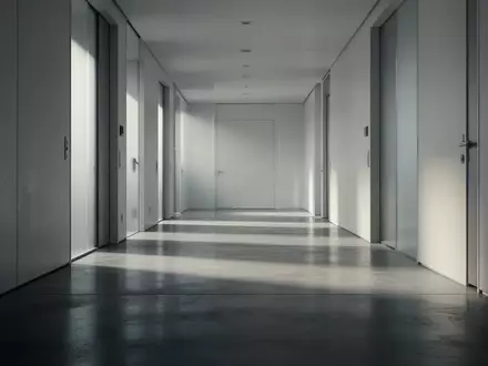 Ein minimalistischer, leerer Flur mit poliertem Betonboden und weichem Lichteinfall, der eine Atmosphäre von Vorsicht und Vertrauen vermittelt. - Foto: über boerse-global.de