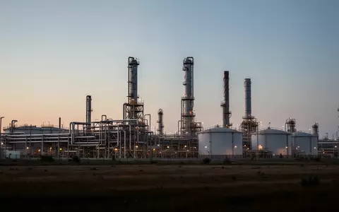 Industrielle Raffinerieanlage mit großen Lagertanks und Rohrleitungssystemen in der Dämmerung. - Foto: über boerse-global.de