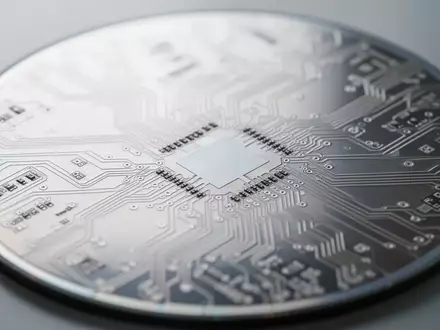 Detailaufnahme einer Silizium-Wafer-Oberfläche mit komplexen Mikrochip-Strukturen unter neutralem Laborlicht. - Foto: über boerse-global.de