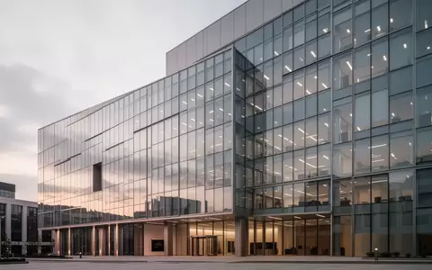 Moderne Glasfassade eines Bürogebäudes in der Dämmerung ohne sichtbare Schriftzüge oder Personen. - Foto: über boerse-global.de