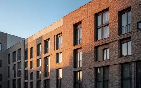 Moderne Wohnhausfassade im warmen Licht der Abendsonne als Symbol für den Ausbau privater Energieerzeugung. - Foto: über boerse-global.de