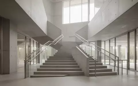 Eine moderne, minimalistische Treppe in einem hellen, institutionellen Gebäude mit klaren Linien und natürlichem Licht. - Foto: über boerse-global.de