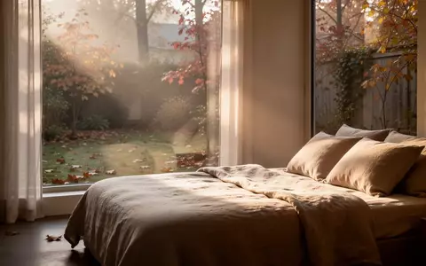 Ein minimalistisches, ruhiges Schlafzimmer am frühen Herbstmorgen mit weichem Tageslicht, das durch ein Fenster fällt. - Foto: über boerse-global.de