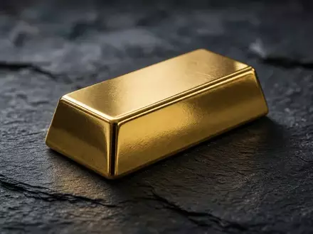 Ein einzelner Goldbarren auf einer dunklen Schieferplatte bei gedämpftem, natürlichem Licht. - Foto: über boerse-global.de