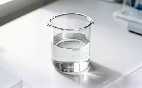 Ein klares Glasgefäß mit Flüssigkeit auf einem sterilen Labortisch in einer klinischen Forschungsumgebung. - Foto: über boerse-global.de
