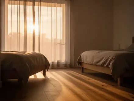 Sanftes Morgenlicht fällt durch einen Vorhang in ein minimalistisch eingerichtetes Zimmer. - Foto: über boerse-global.de