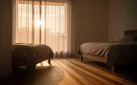 Sanftes Morgenlicht fällt durch einen Vorhang in ein minimalistisch eingerichtetes Zimmer. - Foto: über boerse-global.de