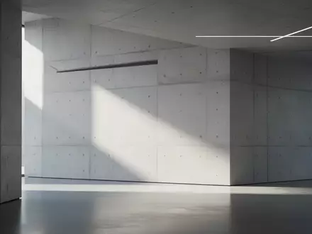 Ein minimalistischer, moderner Innenraum mit klaren, geometrischen Linien und natürlichem Licht auf einer Betonwand. - Foto: über boerse-global.de