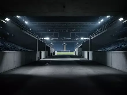 Ein leerer, schattiger Spielertunnel in einem Stadion, der die Atmosphäre von Isolation und Druck symbolisiert. - Foto: über boerse-global.de