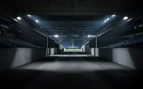 Ein leerer, schattiger Spielertunnel in einem Stadion, der die Atmosphäre von Isolation und Druck symbolisiert. - Foto: über boerse-global.de