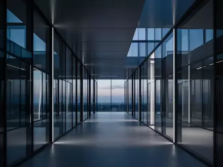Ein minimalistischer Flur in einem modernen Bürogebäude mit geometrischen Linien und blauem Umgebungslicht. - Foto: über boerse-global.de
