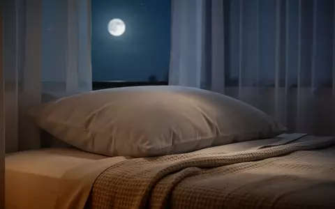 Ein ruhiges, minimalistisches Schlafzimmer bei Nacht mit sanftem Mondlicht, das auf ein bequemes Kissen und Bettwäsche fällt. - Foto: über boerse-global.de