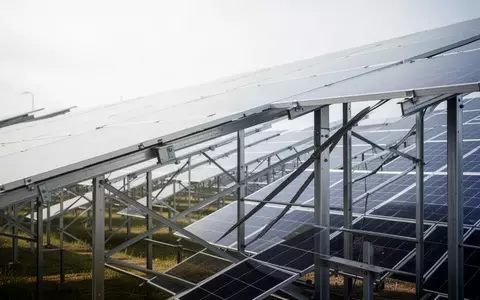 Reihen von Photovoltaikmodulen in einem groĂen Solarpark unter einem bewölkten Himmel. - Foto: ĂŒber boerse-global.de