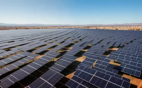 Weitläufiger Solarpark mit zahlreichen Photovoltaik-Modulen unter strahlend blauem Himmel. - Foto: über boerse-global.de