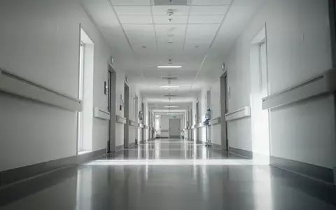 Ein leerer, modern gestalteter Krankenhausflur mit hellen Wänden und glattem Bodenbelag. - Foto: über boerse-global.de