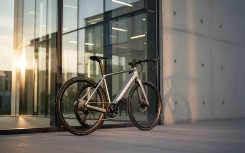 Modernes Fahrrad lehnt vor einem Bürogebäude aus Glas und Beton bei Sonnenlicht. - Foto: über boerse-global.de