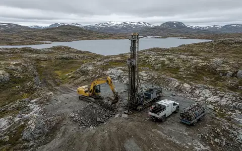 Industriegelände mit schwerem Gerät zur Ressourcenerkundung in einer weitläufigen Landschaft bei Tageslicht. - Foto: über boerse-global.de