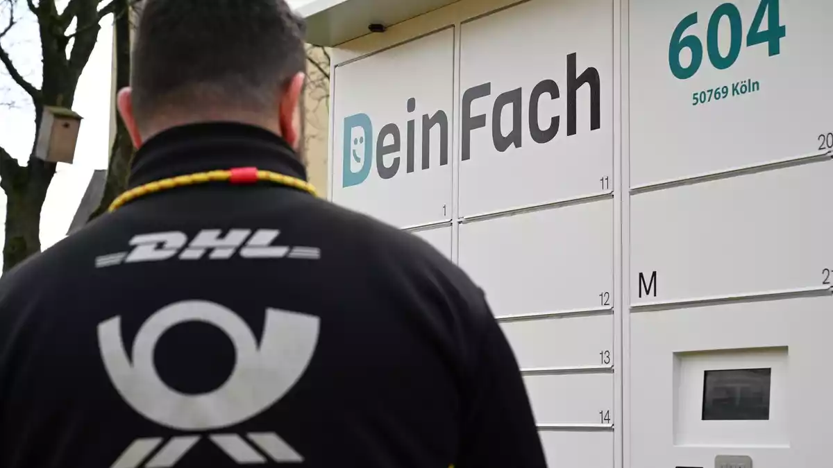 Ein DHL-Paketbote holt Sendungen aus einem DeinFach-Automaten. - Bild: Wolf von Dewitz/dpa