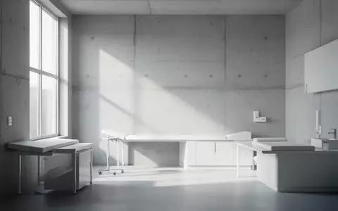 Ein minimalistisch gestalteter, leerer Praxisraum mit hellem Tageslicht und weichen Schatten an einer Wand. - Foto: über boerse-global.de
