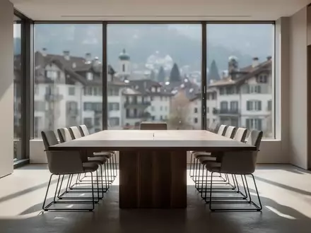 Ein minimalistischer, heller Konferenzraum in einem modernen Bürogebäude mit Blick auf eine Schweizer Stadt. - Foto: über boerse-global.de