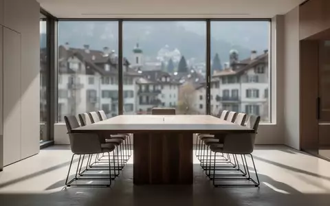Ein minimalistischer, heller Konferenzraum in einem modernen Bürogebäude mit Blick auf eine Schweizer Stadt. - Foto: über boerse-global.de