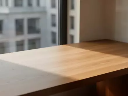 Ein minimalistischer, leerer Schreibtisch in hellem, natürlichem Licht mit einem neutralen architektonischen Hintergrund. - Foto: über boerse-global.de