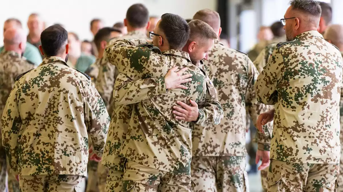 Soldaten umarmen sich nach ihrer Rückkehr aus dem Irak. - Bild: Michael Matthey/dpa